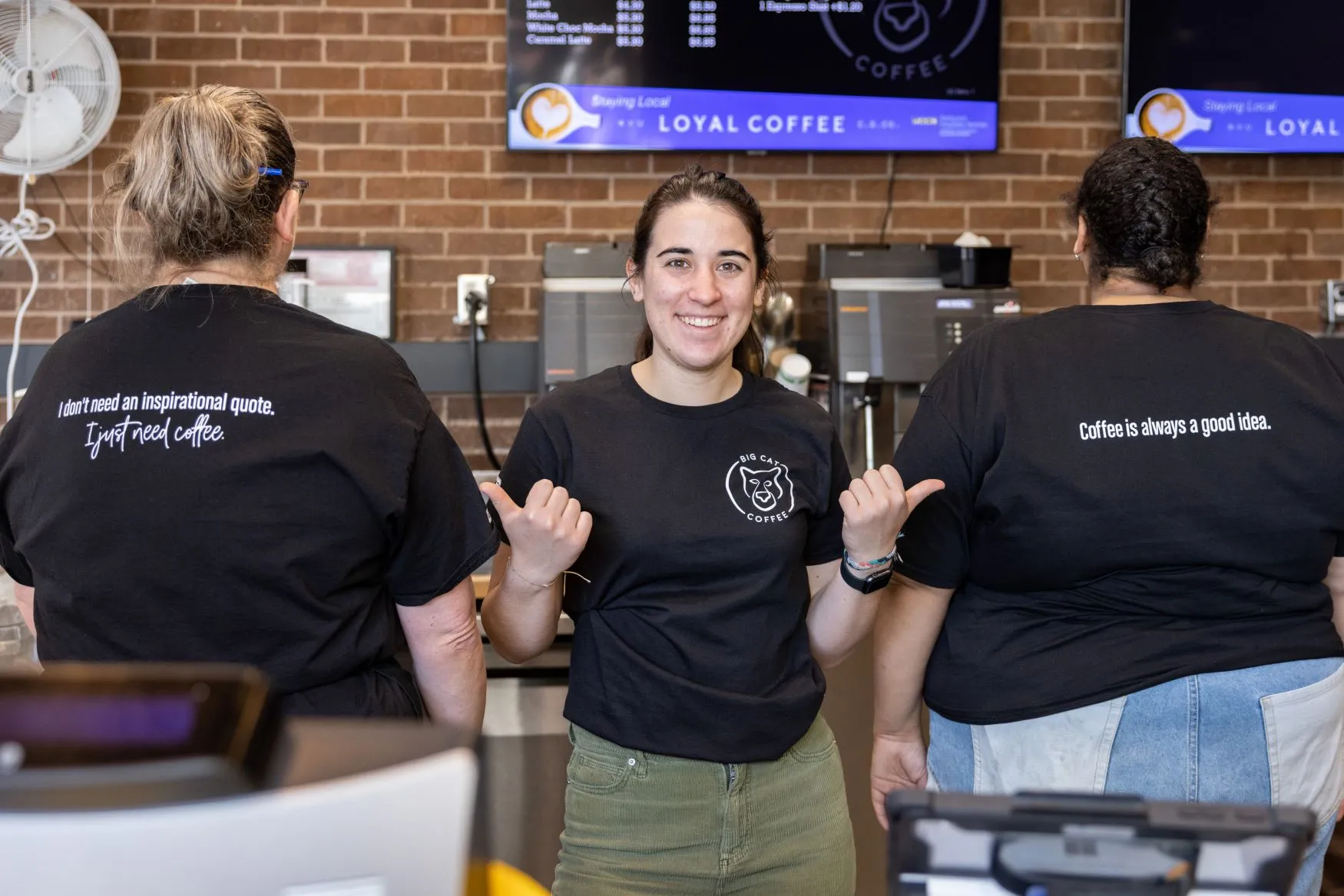 Big Cat Coffee Workers showing off their shirts